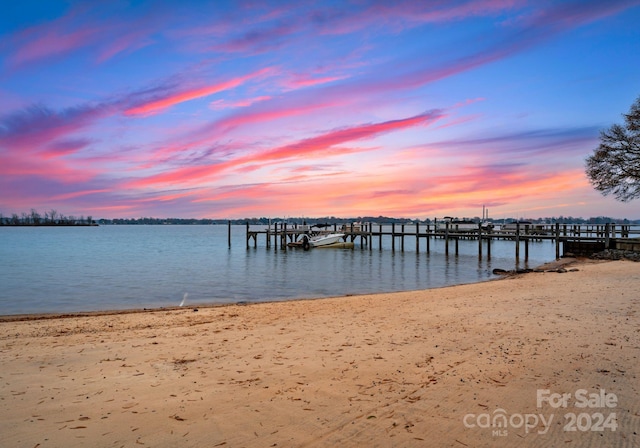 dock area featuring a beach view and a water view