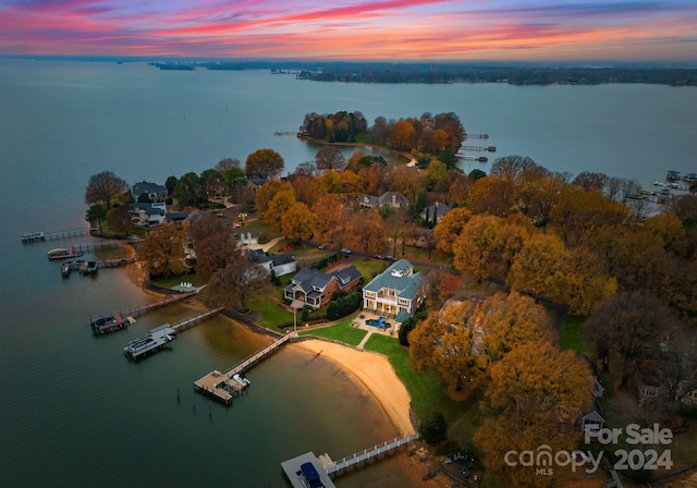 aerial view at dusk featuring a water view