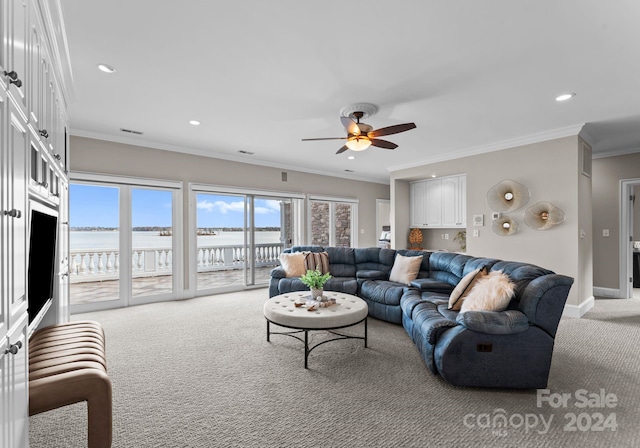 carpeted living room with crown molding, a water view, and ceiling fan