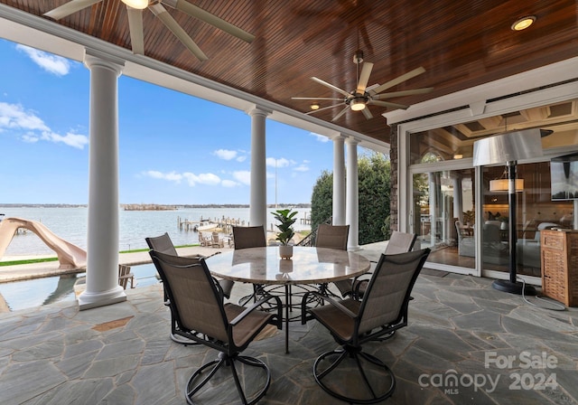 unfurnished sunroom featuring a wealth of natural light, a water view, ceiling fan, and wood ceiling