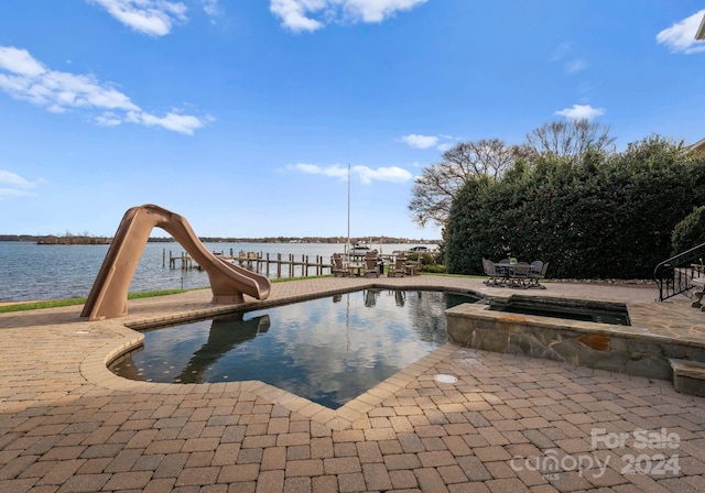 view of pool with a water view, a water slide, and a patio