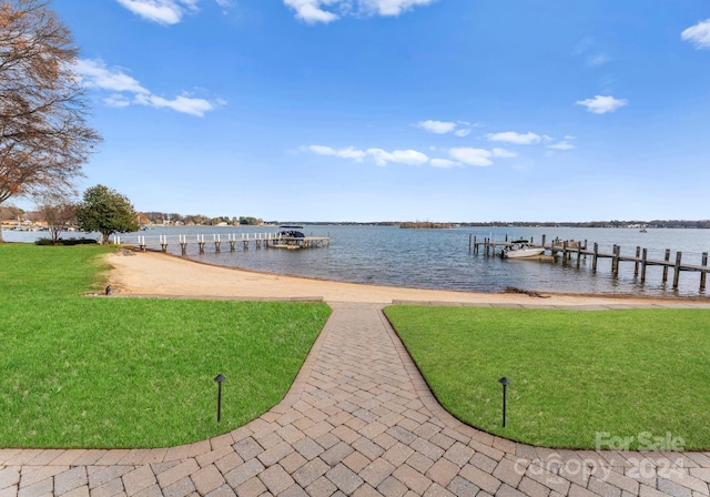 dock area with a water view and a yard