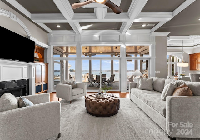 living room featuring ceiling fan, beamed ceiling, light hardwood / wood-style floors, and ornamental molding