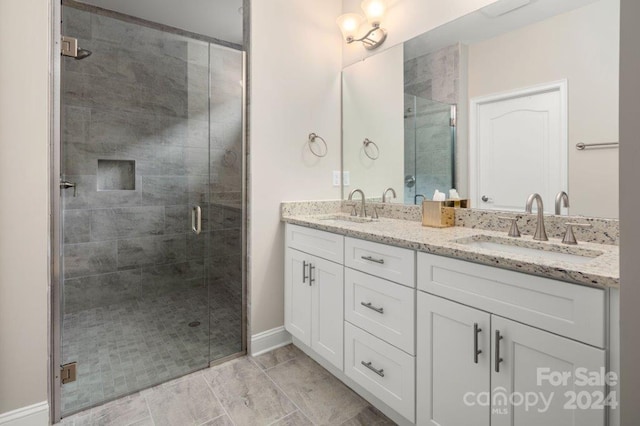 bathroom with tile patterned flooring, vanity, and walk in shower