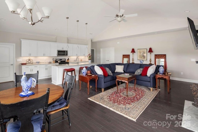 dining area featuring ceiling fan with notable chandelier, dark wood-style floors, baseboards, and high vaulted ceiling