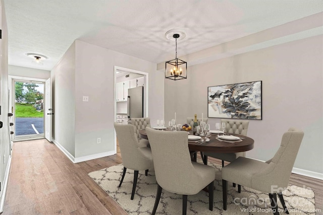 dining space with wood-type flooring and a chandelier