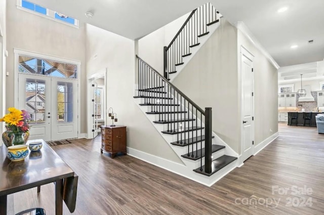 staircase featuring wood-type flooring and french doors