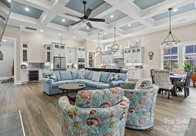 living room with a high ceiling, coffered ceiling, beverage cooler, and wood-type flooring