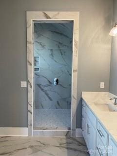 bathroom featuring tiled shower and vanity