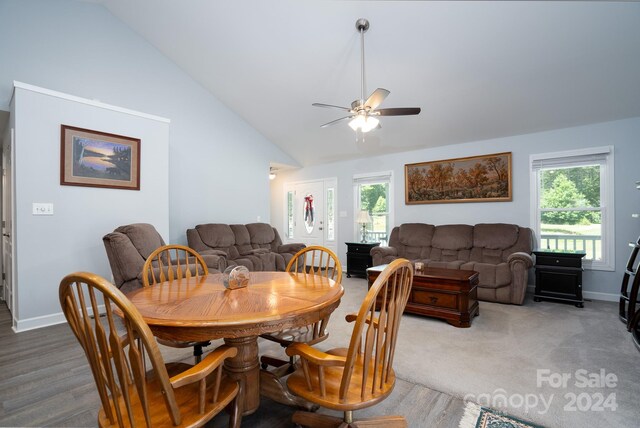 dining space with carpet, ceiling fan, plenty of natural light, and high vaulted ceiling