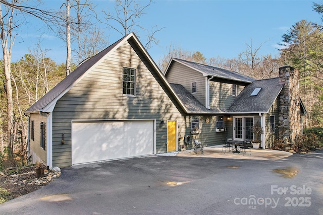 view of front of home with a garage and a patio