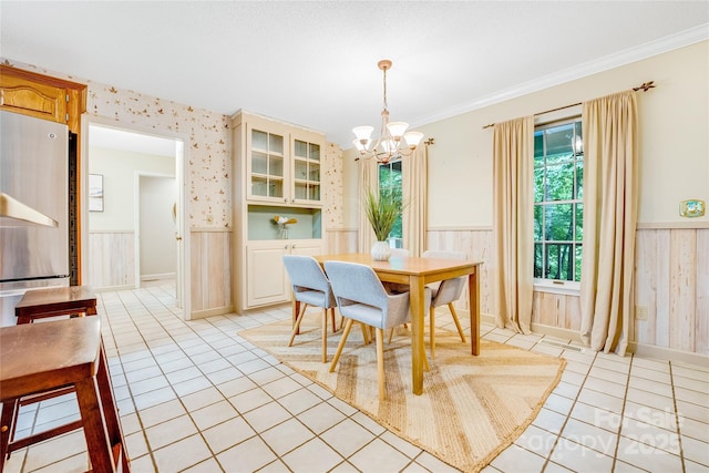 dining area featuring a notable chandelier, crown molding, and light tile patterned floors