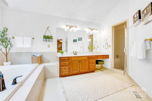 bathroom with independent shower and bath, tile patterned floors, and vanity