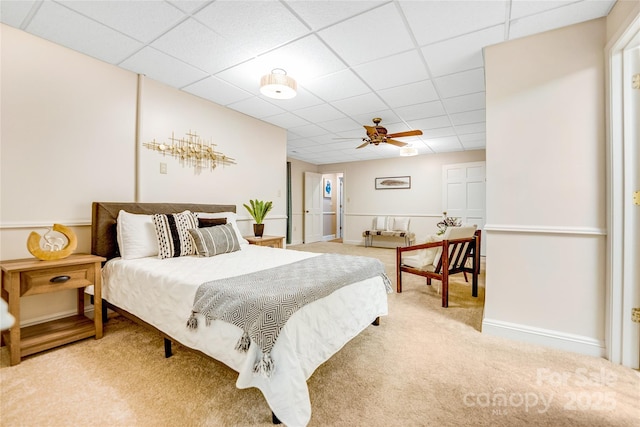 carpeted bedroom featuring ceiling fan and a paneled ceiling