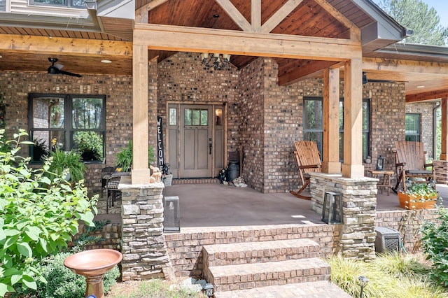 view of exterior entry with covered porch and ceiling fan