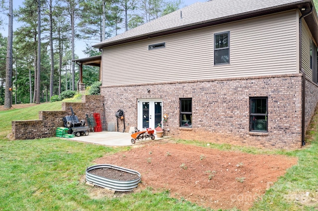 rear view of property featuring a yard, french doors, and a patio