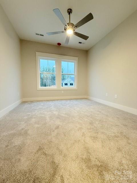 unfurnished room featuring carpet and ceiling fan