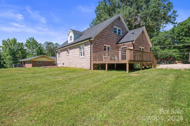 rear view of house with a lawn and a wooden deck