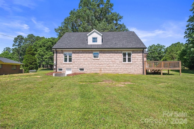 rear view of house featuring a deck and a yard