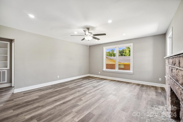 unfurnished living room featuring a fireplace, hardwood / wood-style floors, and ceiling fan