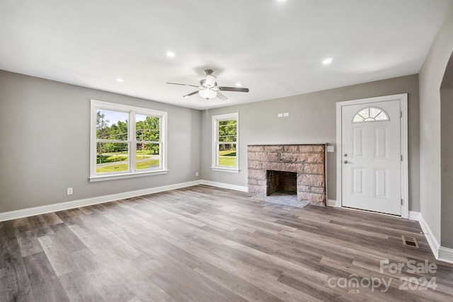 unfurnished living room with ceiling fan, a fireplace, and hardwood / wood-style flooring