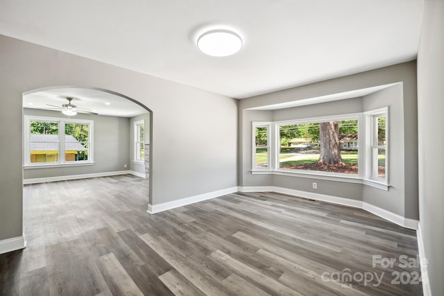 empty room with hardwood / wood-style floors and ceiling fan