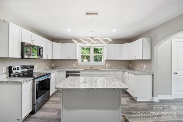 kitchen with stainless steel appliances, a kitchen island, and white cabinetry