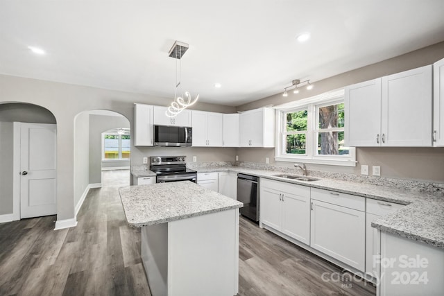 kitchen featuring white cabinetry, a center island, pendant lighting, and appliances with stainless steel finishes