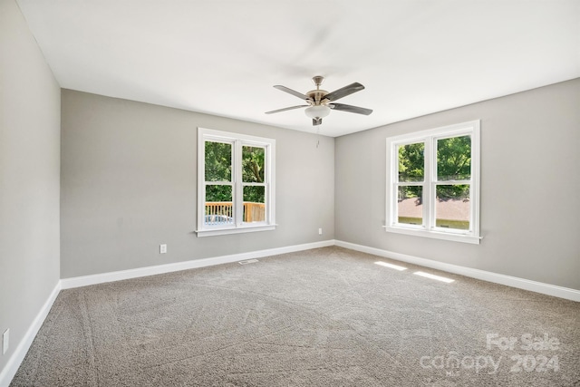 unfurnished room featuring carpet, a wealth of natural light, and ceiling fan