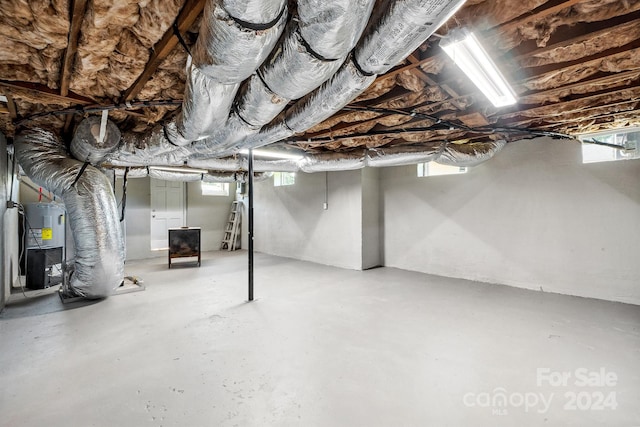 basement featuring a wealth of natural light and electric water heater