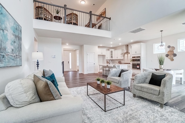 living room with sink, hardwood / wood-style flooring, and a high ceiling