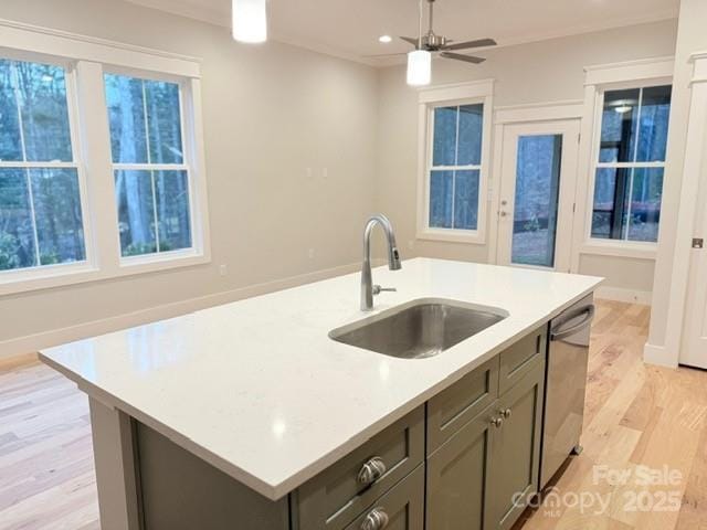 kitchen featuring a center island with sink, dishwasher, light hardwood / wood-style floors, a wealth of natural light, and sink