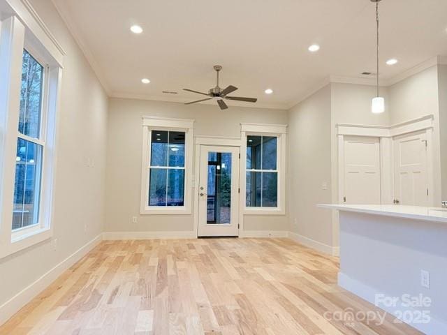 unfurnished living room featuring ceiling fan, light hardwood / wood-style floors, and crown molding