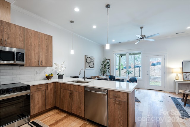 167 Collin Pl Unit 21, Asheville, NC 28804 - kitchen featuring a sink, a peninsula, appliances with stainless steel finishes, light countertops, and light wood-style floors