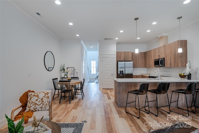 167 Collin Pl Unit 21, Asheville, NC 28804 - kitchen featuring a peninsula, stainless steel appliances, a kitchen breakfast bar, and brown cabinets