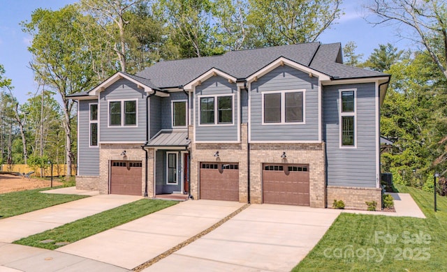 167 Collin Pl Unit 21, Asheville, NC 28804 - townhome / multi-family property featuring concrete driveway, brick siding, a front yard, and a garage