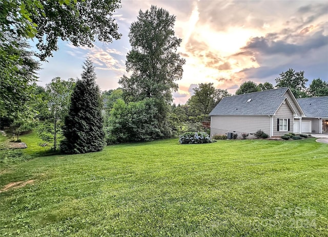 yard at dusk featuring central air condition unit