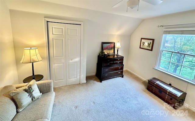 sitting room with ceiling fan, light colored carpet, and vaulted ceiling