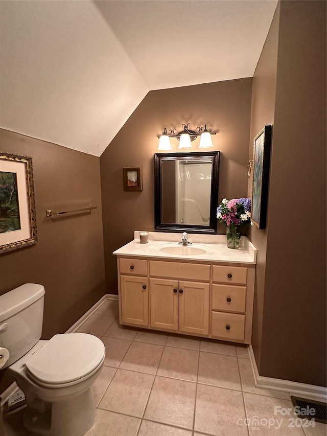 bathroom featuring tile patterned floors, vanity, lofted ceiling, and toilet