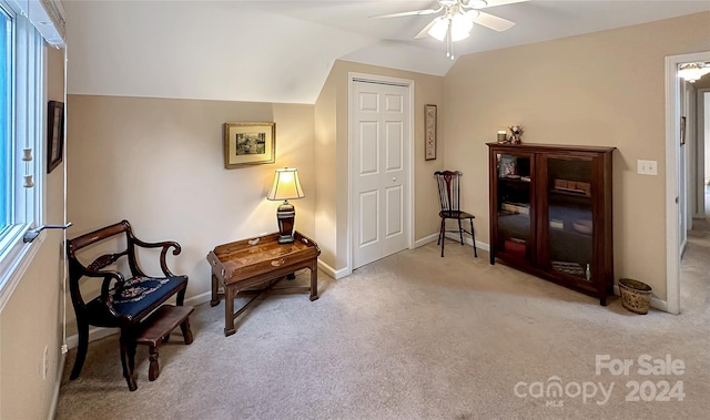 living area featuring vaulted ceiling, ceiling fan, and light carpet