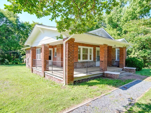 view of front of home with a front yard and covered porch