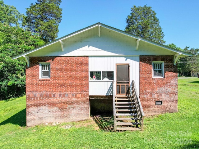 rear view of property featuring a yard