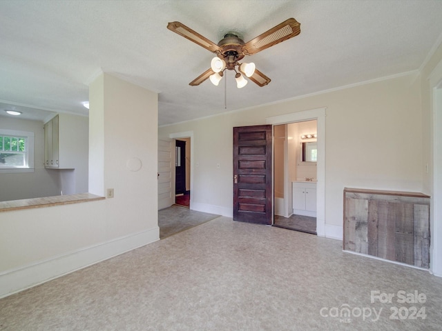 unfurnished room with ceiling fan and ornamental molding