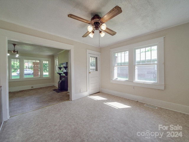 interior space with ceiling fan, a healthy amount of sunlight, carpet flooring, and a textured ceiling