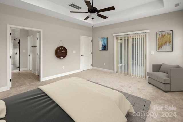 bedroom with a raised ceiling, ceiling fan, and light colored carpet