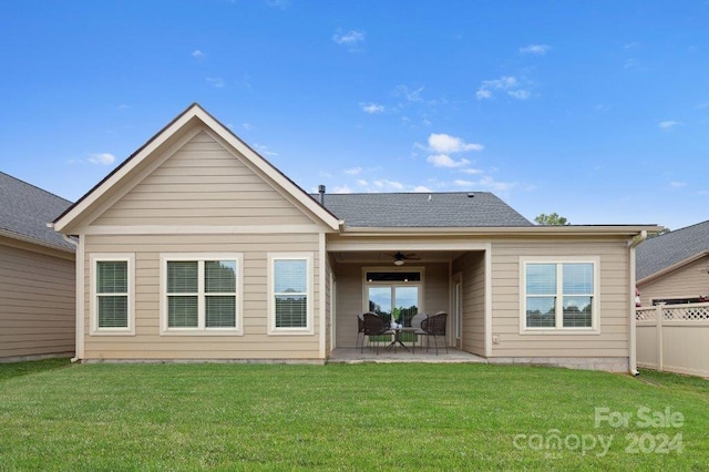 rear view of house featuring ceiling fan, a patio area, and a lawn