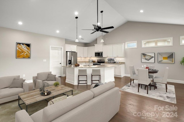 living room with ceiling fan, sink, dark wood-type flooring, and high vaulted ceiling