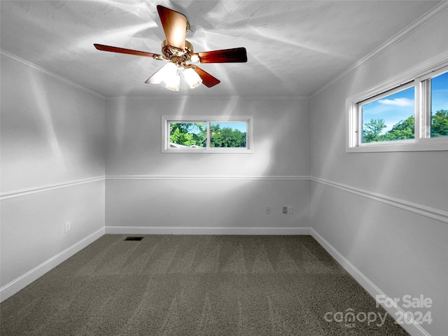 carpeted spare room featuring plenty of natural light, ornamental molding, and ceiling fan