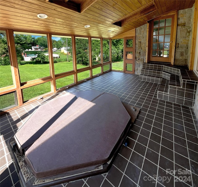 unfurnished sunroom featuring lofted ceiling and wooden ceiling