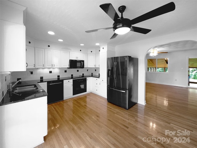 kitchen with light wood-type flooring, backsplash, sink, black appliances, and white cabinets